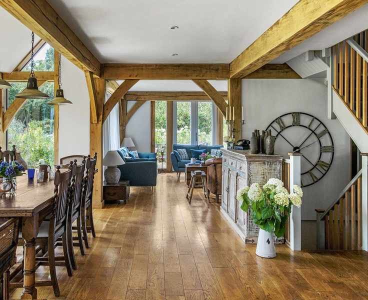 Open plan living room with wooden floors, white walls and beams