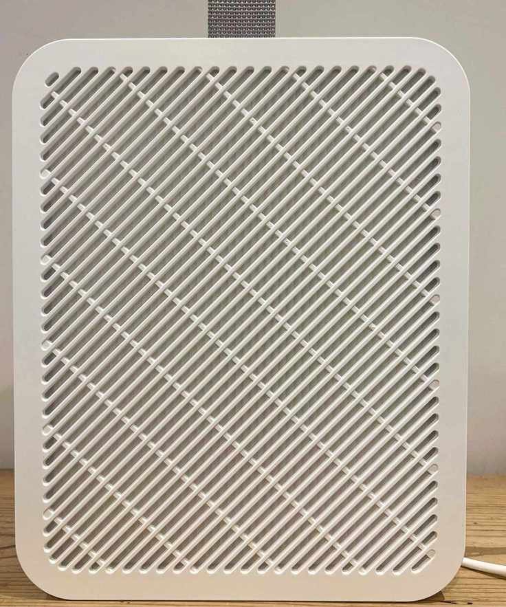 A white IKEA UPPÅTVIND Air purifier on a wooden table against a white wall.