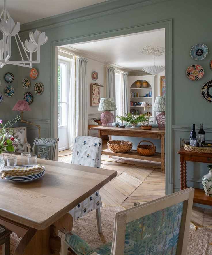blue painted dining room filled with pretty vintage cottage style pieces with an open plan view through to the kitchen