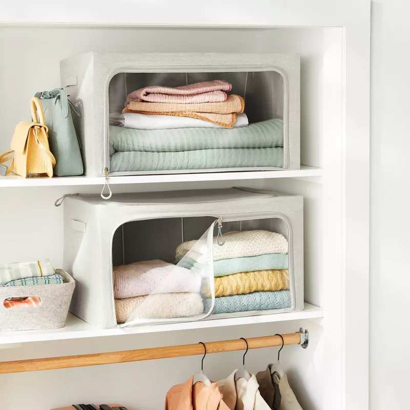 Two clear front clothes storage boxes on closet shelves