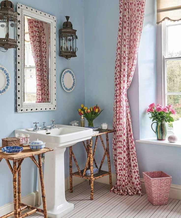 A blue bathroom with a pink curtain