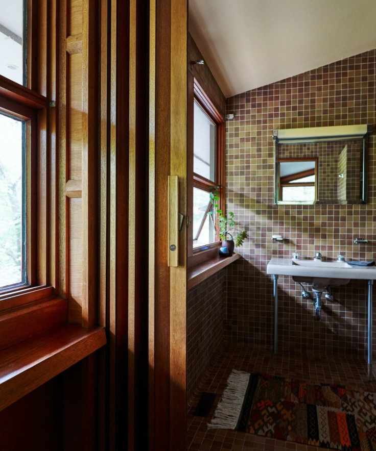Midcentury bathroom with small mosaic tiles, retro silver sink and wood panelled window