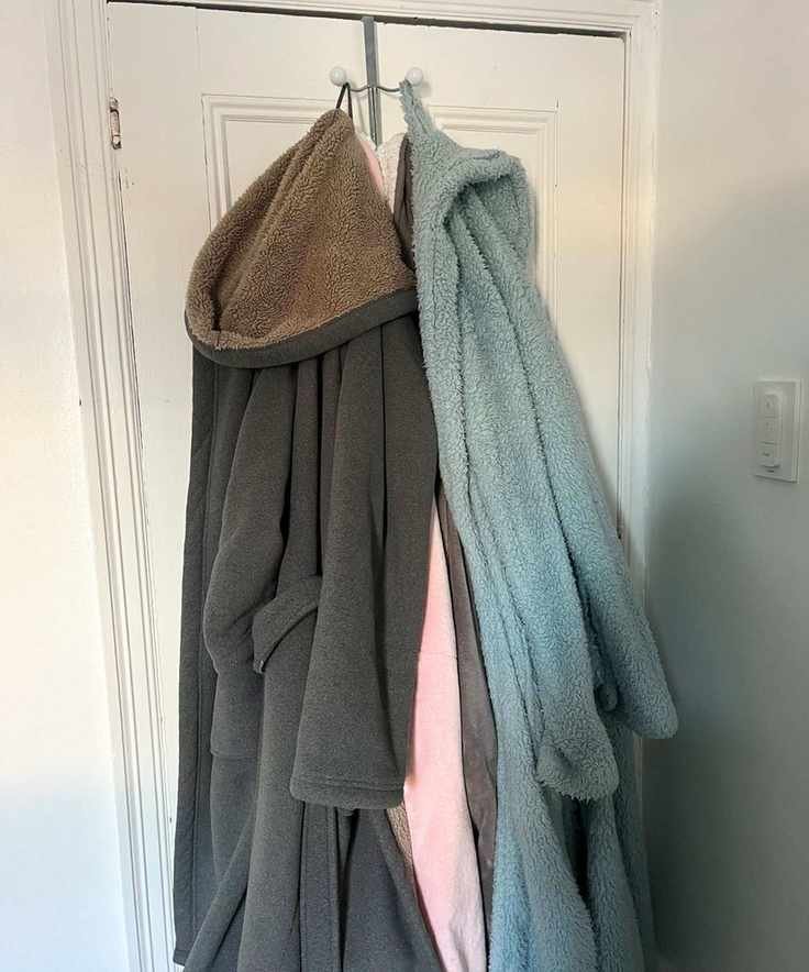 Dressing gowns hanging on the back of a white painted door
