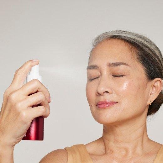 Image of model applying setting spray to their face