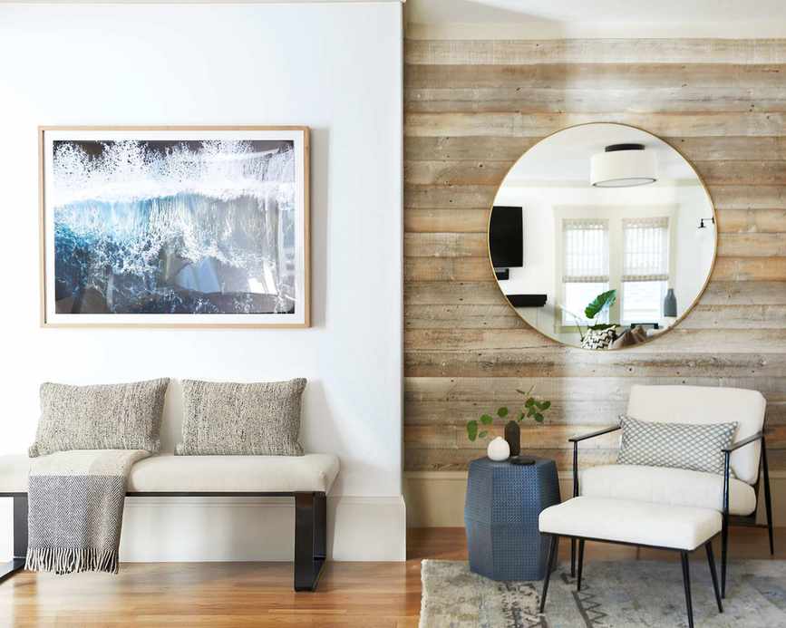 Modern entryway with half panel wall, round mirror and bench