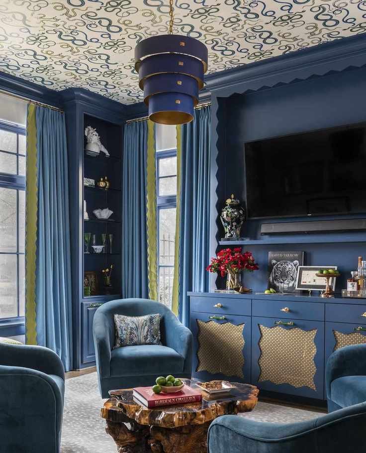 blue media room with blue tub armchairs and big tv on wall