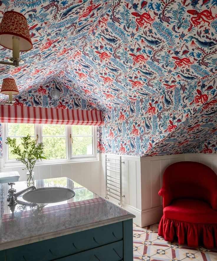 Decorative bathroom with colorful blinds and red slipper chair