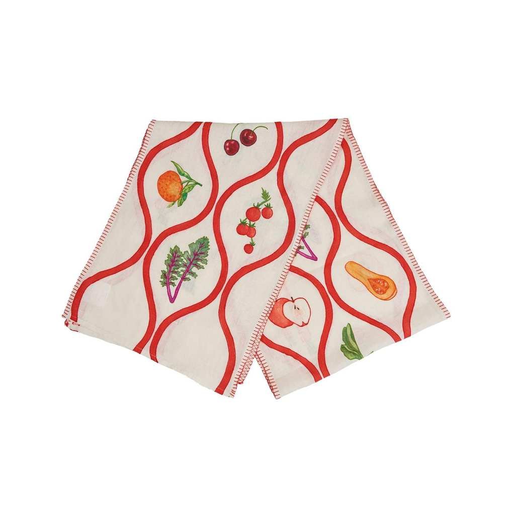 A table runner with a red ribbon pattern and embroidered fruits and vegetables on it