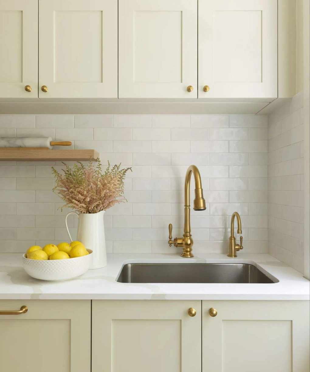 neutral kitchen with subway tiles and a brass faucet