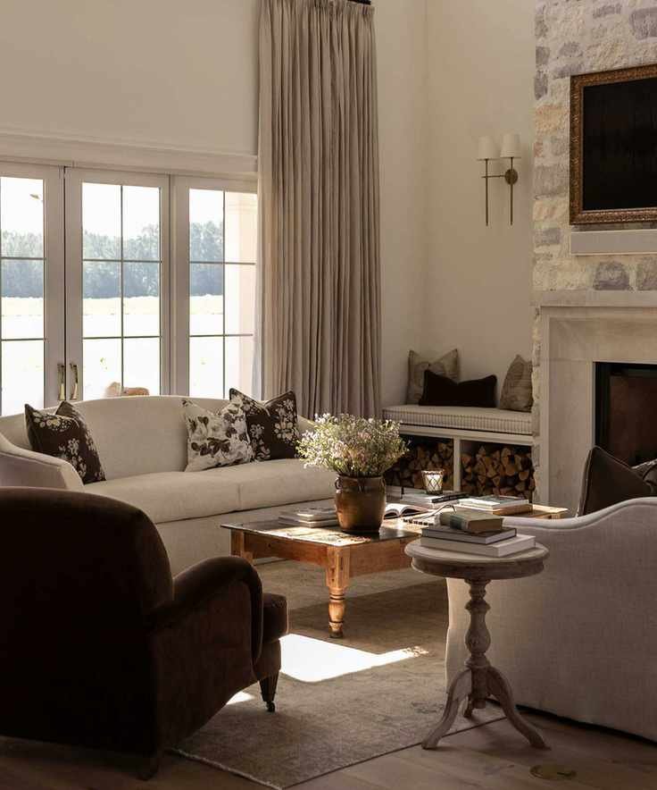 neutral farmhouse living room with two white couches facing each other opposite a stone fireplace