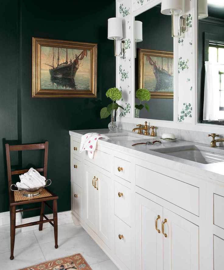 A bathroom showcasing dark green and floral decor with a cream vanity