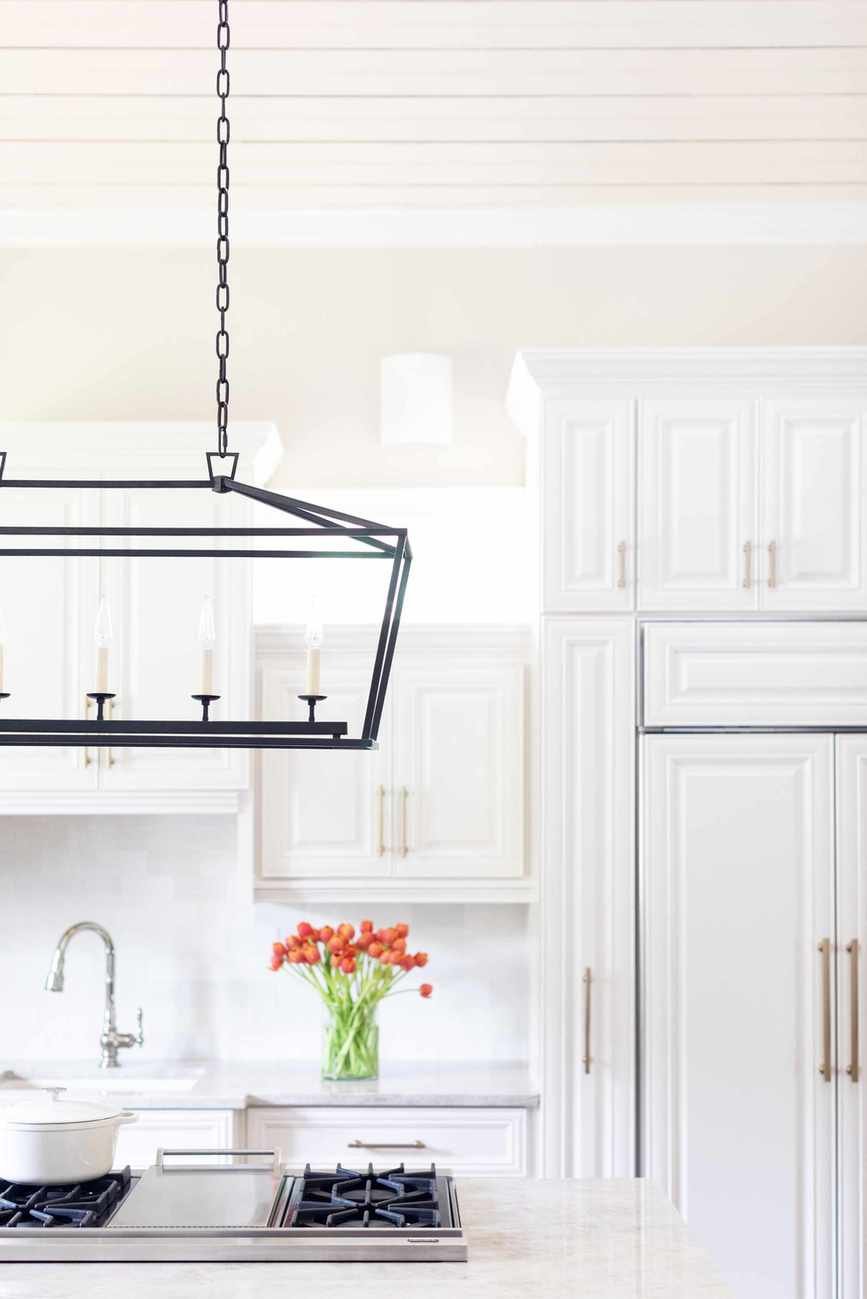 Kitchen with white cabinets, island and pendant light