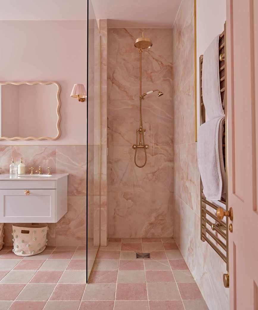 A pink guest bathroom with gold hardware