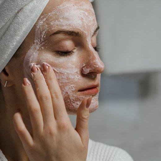 Image of model putting skin care products on their face