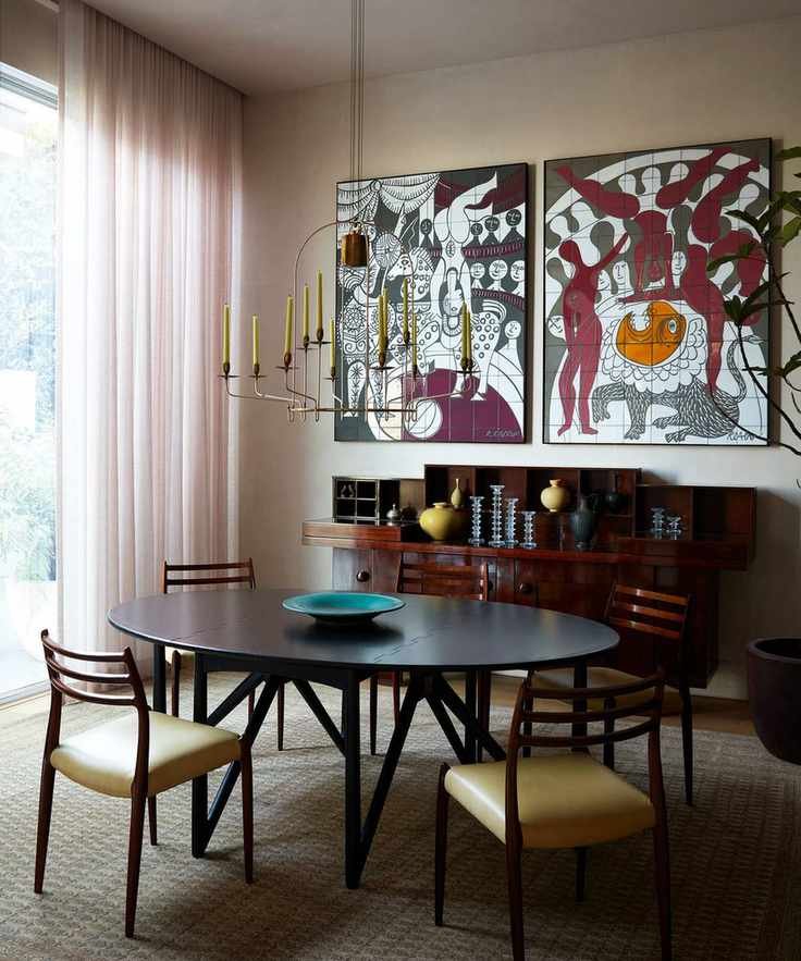 Modern dining room with dark wood table and chairs with large art on wall and modern pendant
