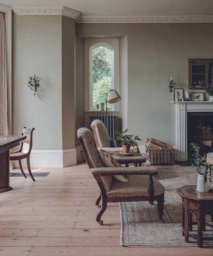 living space with light green walls and antique wooden chairs and wooden floors and sidetable and rug