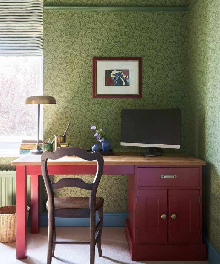Wallpapered green floral home office with a red desk