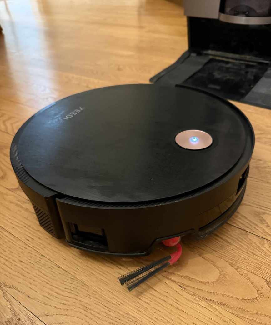 The Yeedi S20 Infinity with side brush visible and base station in background
