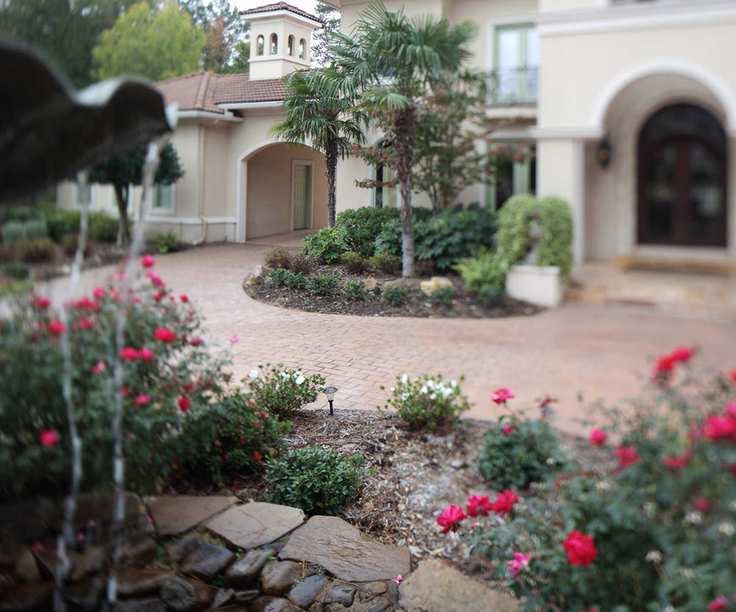 A front driveway with planting beds filled with flowers
