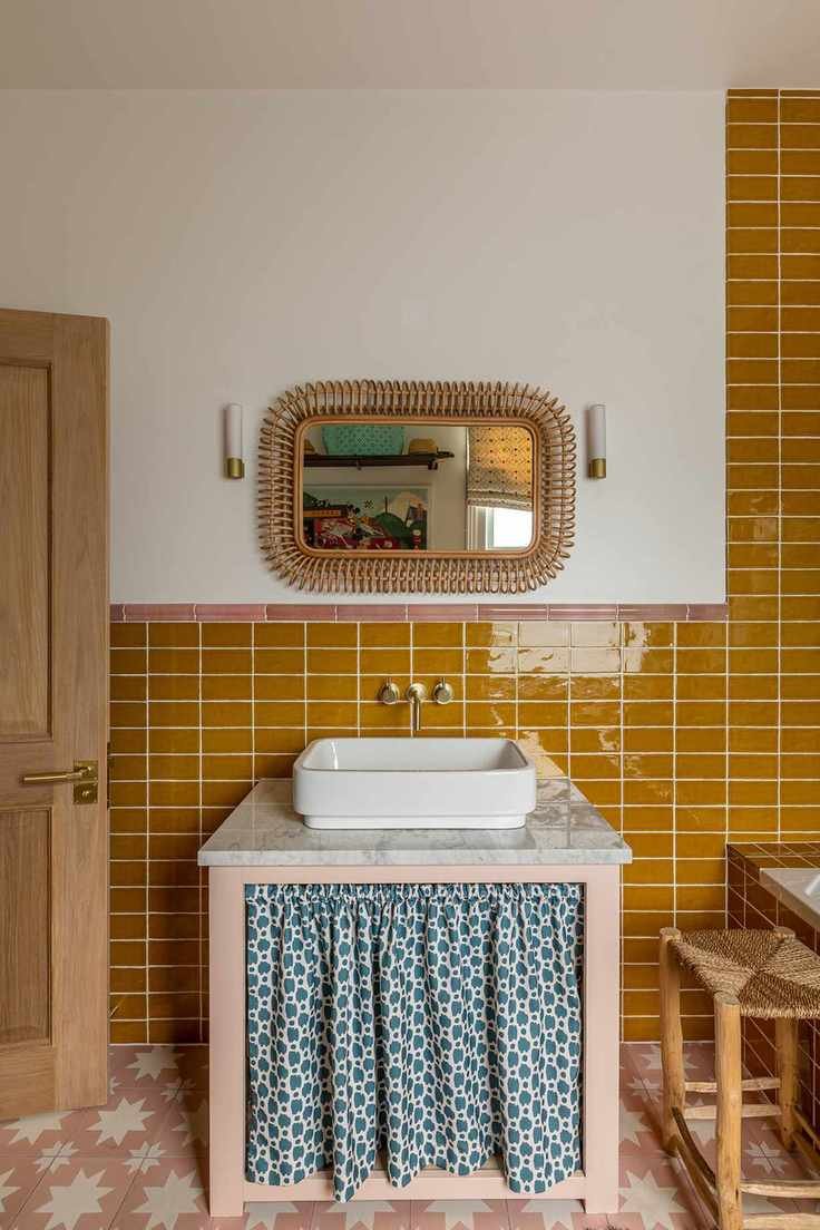 Bathroom with yellow subway tiles and vanity with blue sink skirt