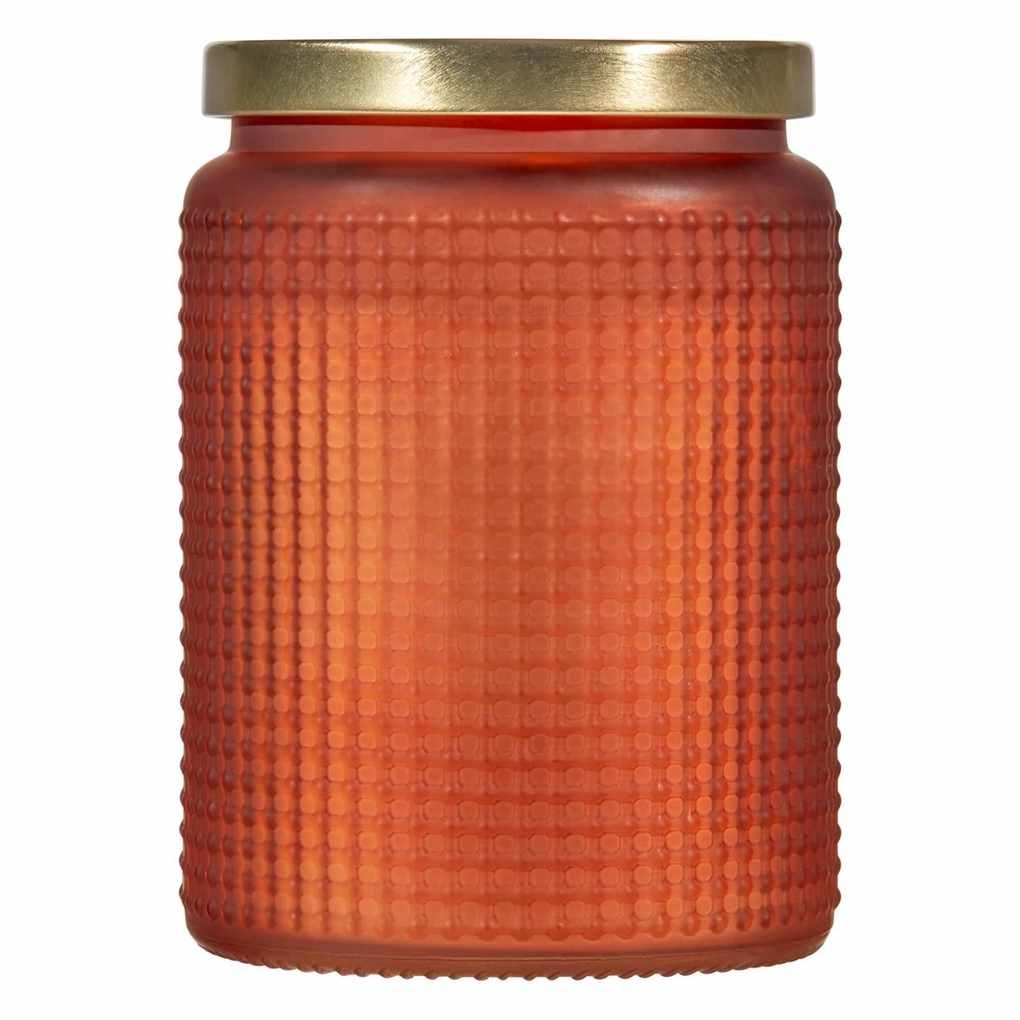 An orange textured glass candle with gold lid