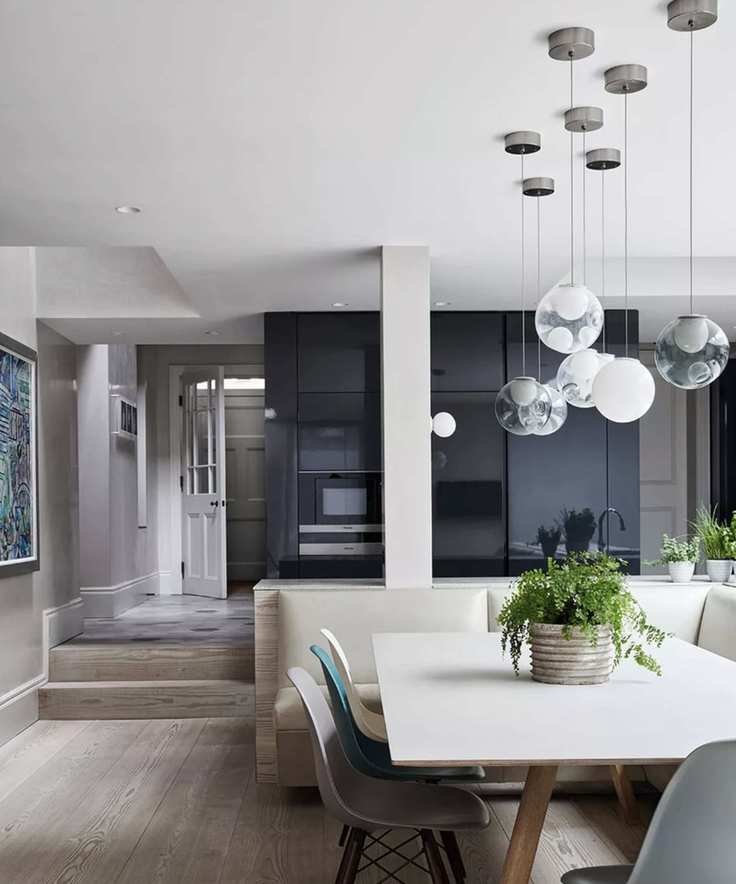 Painting kitchen cabinets without sanding, featuring midnight blue cabinetry and cream seating around a white table.