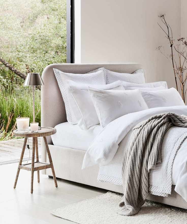 make your home feel like a sanctuary, white bedroom, oatmeal bedhead, rattan stool, view of outside