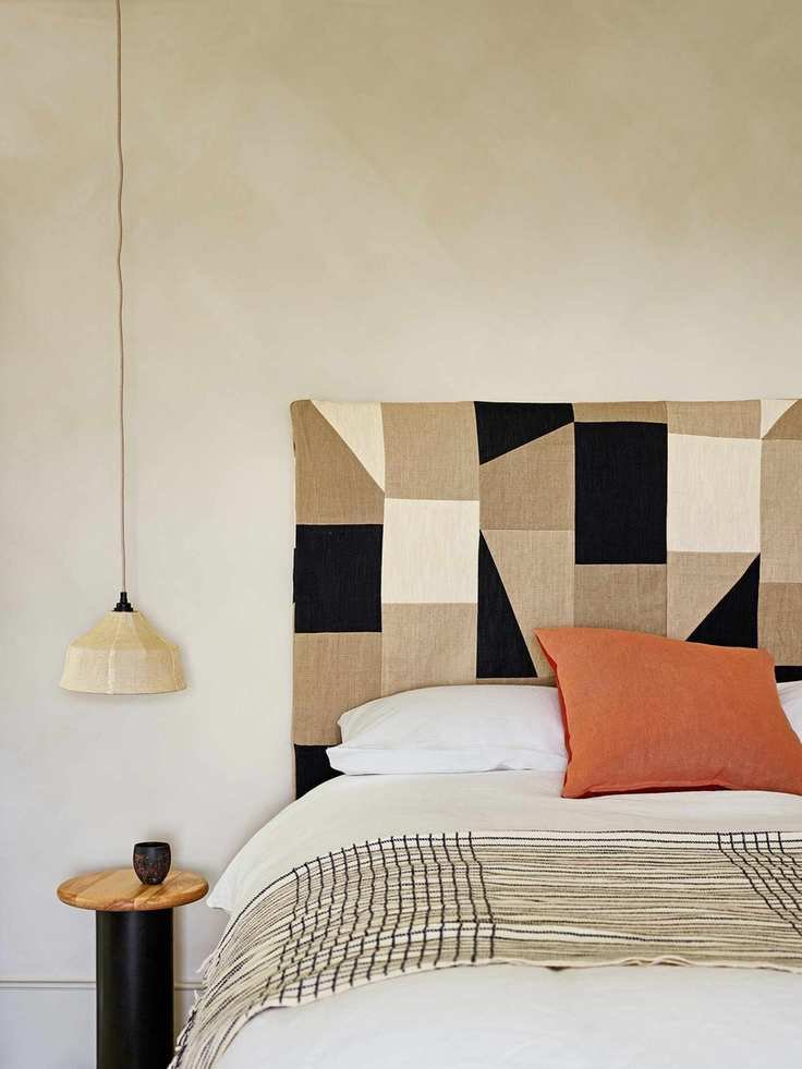 Stylish beige bedroom featuring a geometric fabric headboard
