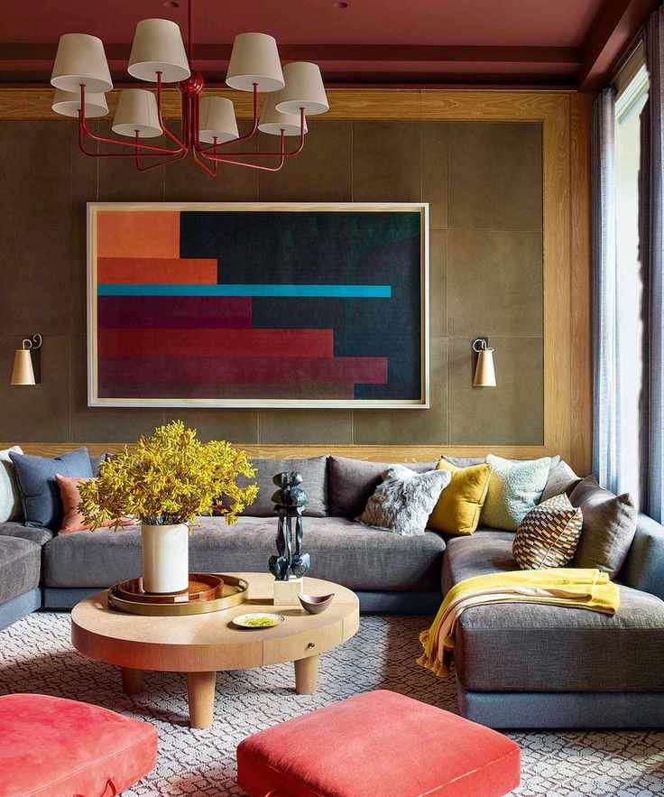 Cozy corner with grey u-shaped sofa and brown walls with art