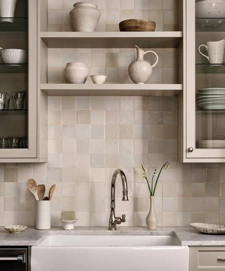 kitchen sink detail with cream tiles cabinets and ceramics
