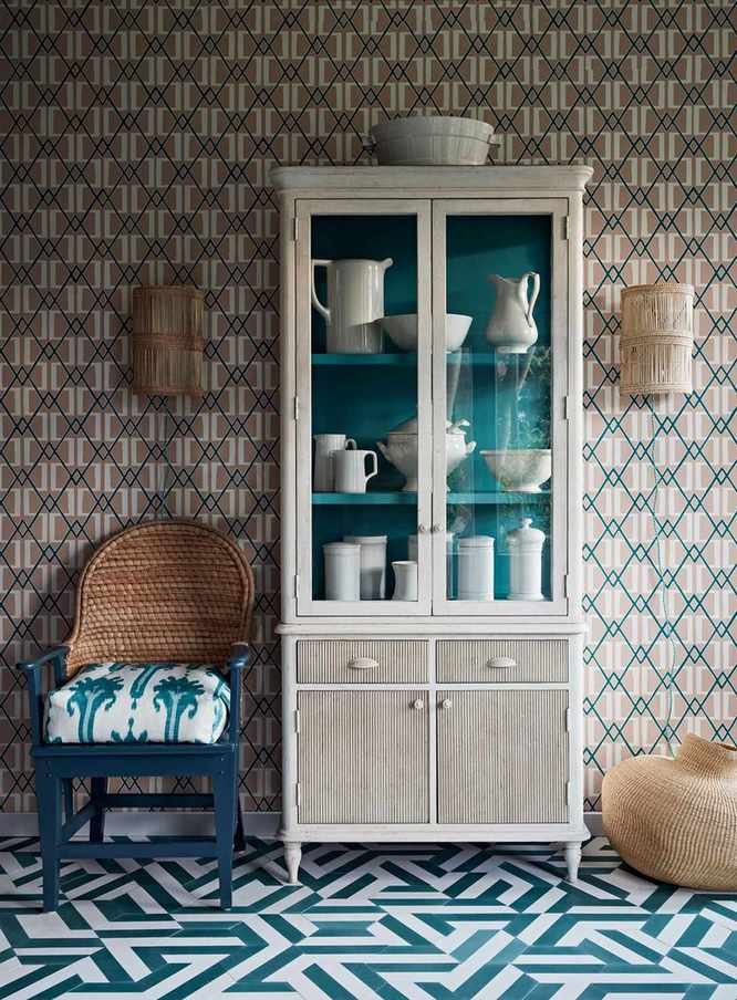 Living room paint ideas showing painted furniture alongside contrasting patterns on the wallpaper and flooring, all in shades of blue and wood tones.