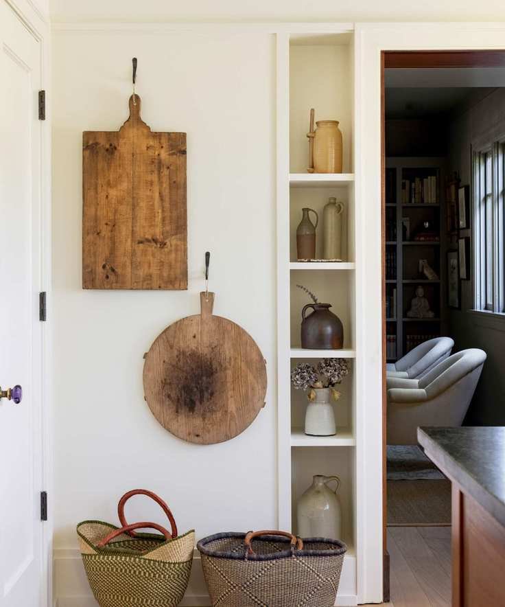 chopping boards and baskets in kitchen with narrow display shelves and wooden floors