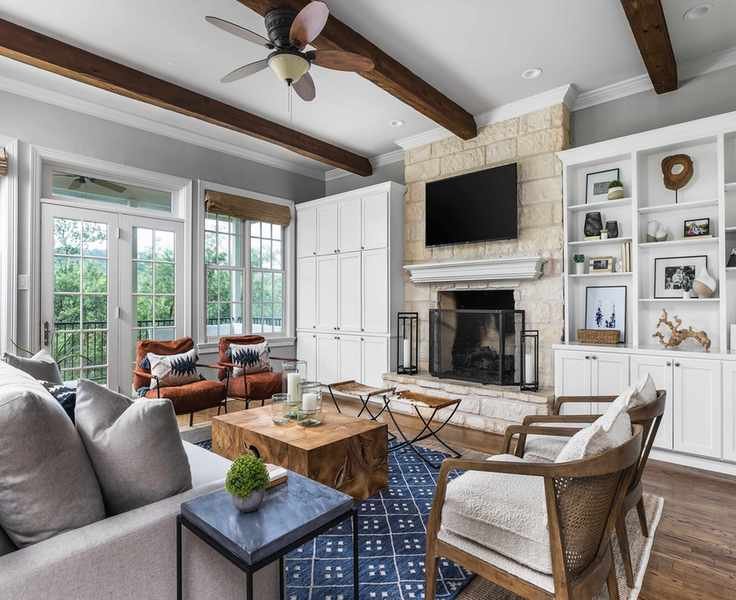 A neutral scheme with blue rug and exposed beams illustrating how to design a living room.