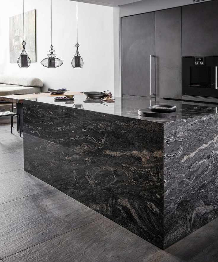 A black kitchen idea with large black marble island and black cabinets