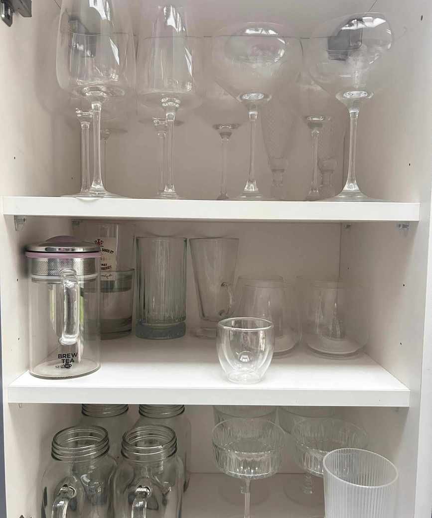 Kitchen cupboard with messy glassware 