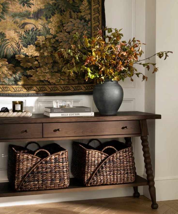 entryway vignette with a dark wood bobbin console table