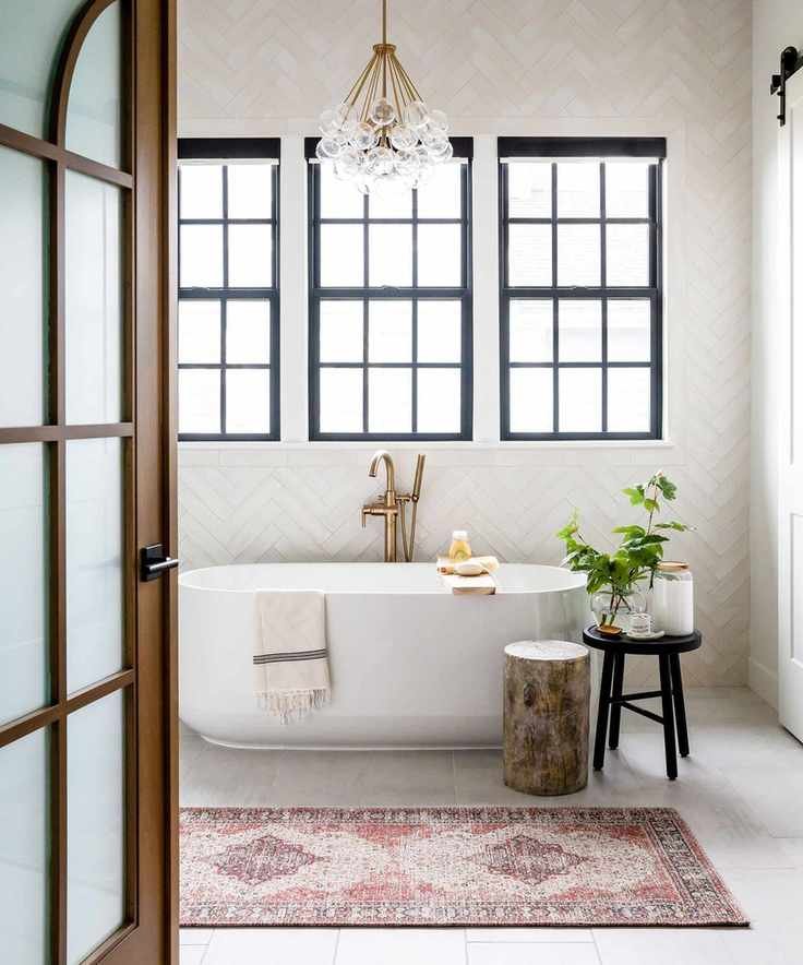 A rolltop bath by a window with an oriental rug
