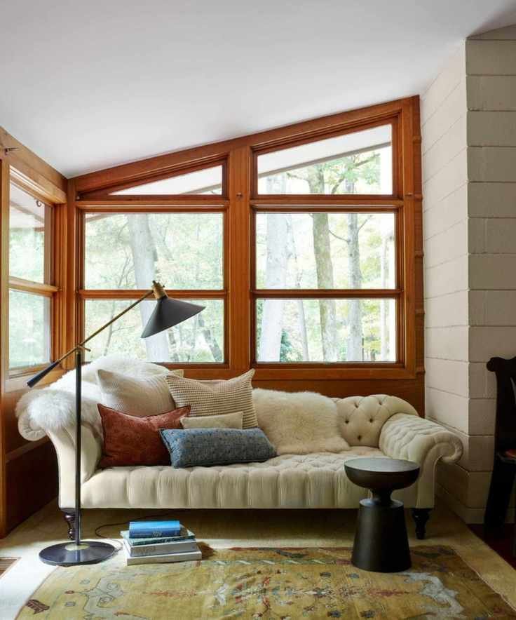 Midcentury living room with wood windows, cream sofa and midcentury floor lamp