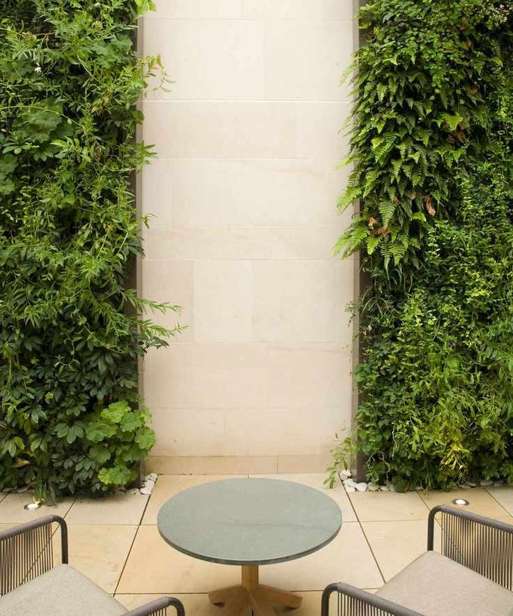 A vibrant living wall adorned with various plants and stones