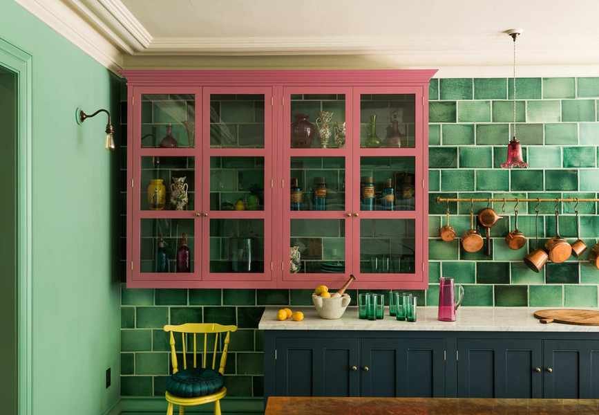Kitchen with green tile wall, blue floor cabinets and pink wall cabinets