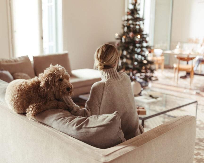 Woman with dog by Christmas tree