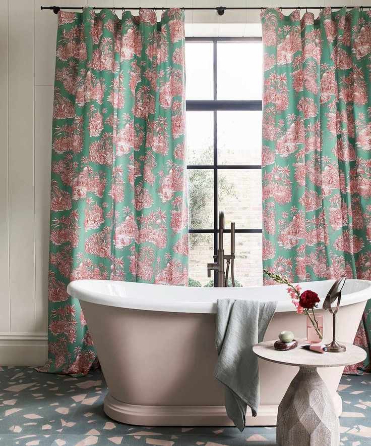 freestanding pink painted bath with toile curtains and terrazzo floor tiles