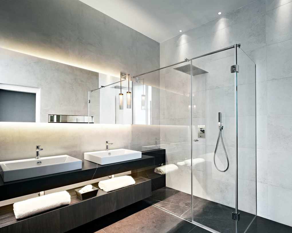 Bathroom with LED strip lighting and light gray wall tiles