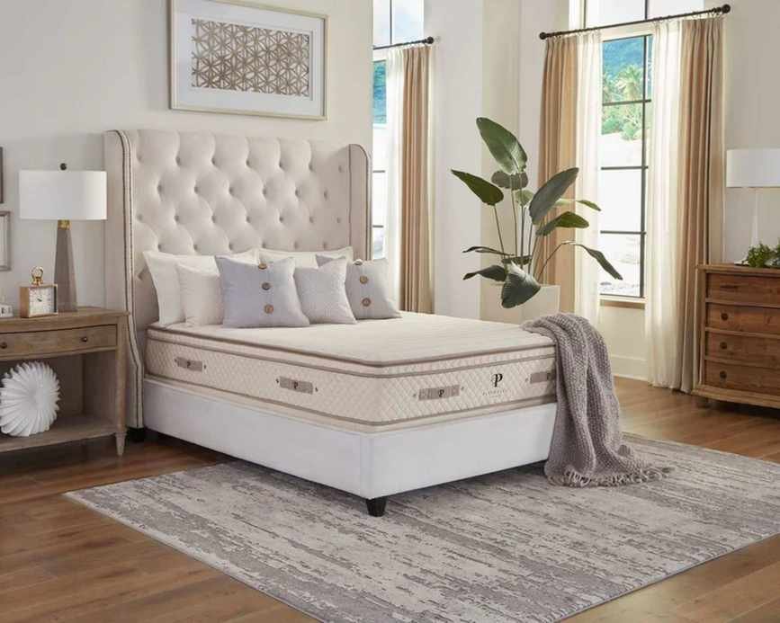 A PlushBeds Organic Latex Mattress on a bed in a neutral bedroom.