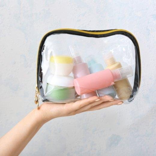 Image of hand model holding a bag of travel skin care products