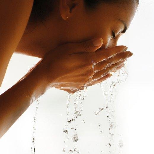 Image of model splashing water on their face