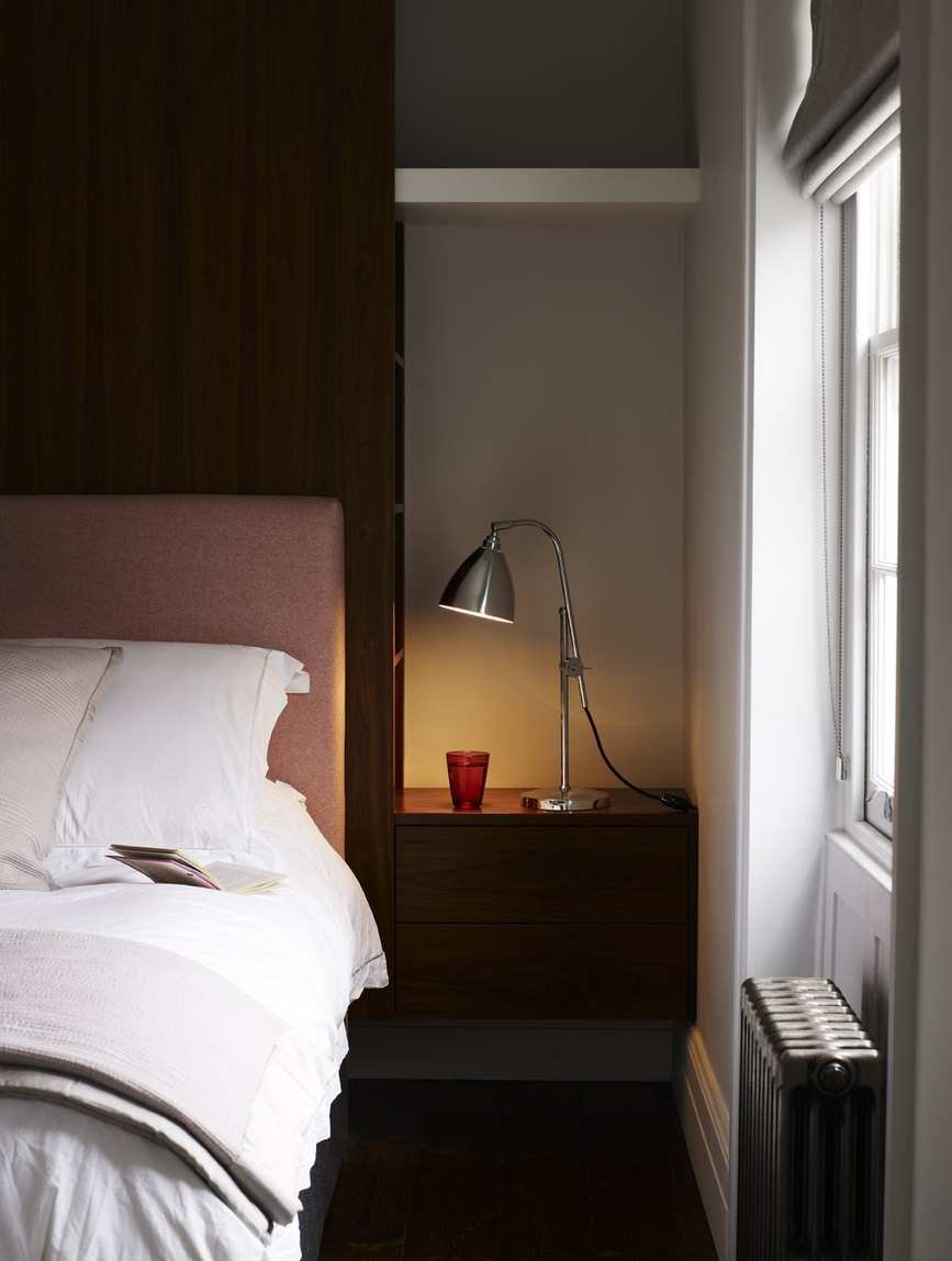 bedroom with alcove and fitted side table, lamp and shelf
