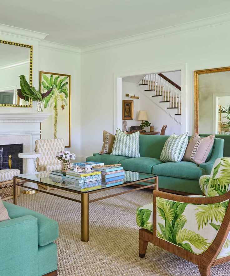 warm vs cool colors, green and white/neutral living room with botanical prints, mirrors, two green couches, botanical print upholstered armchair