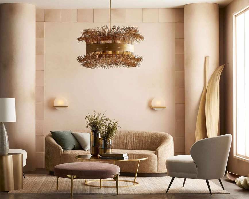 Arteriors gold chandelier showing how to plan living room lighting in a pale pink room with pastel furniture.