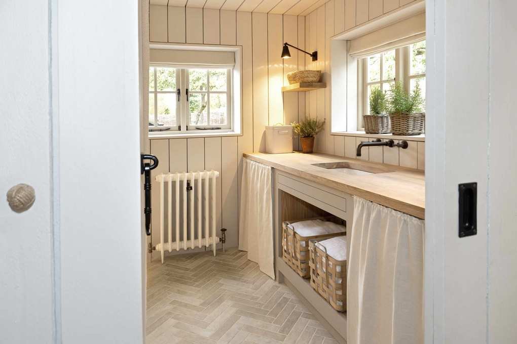 Narrow utility room with herringbone flooring and fabric drapes
